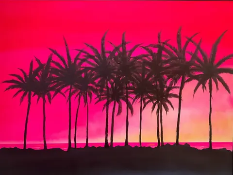 ピンクから朱の夕焼けに並ぶヤシの木のシルエット