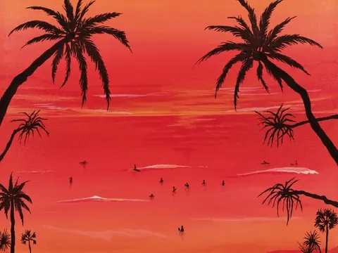 ヤシの額縁に囲まれた赤い夕焼けの海と波待ちのサーファー